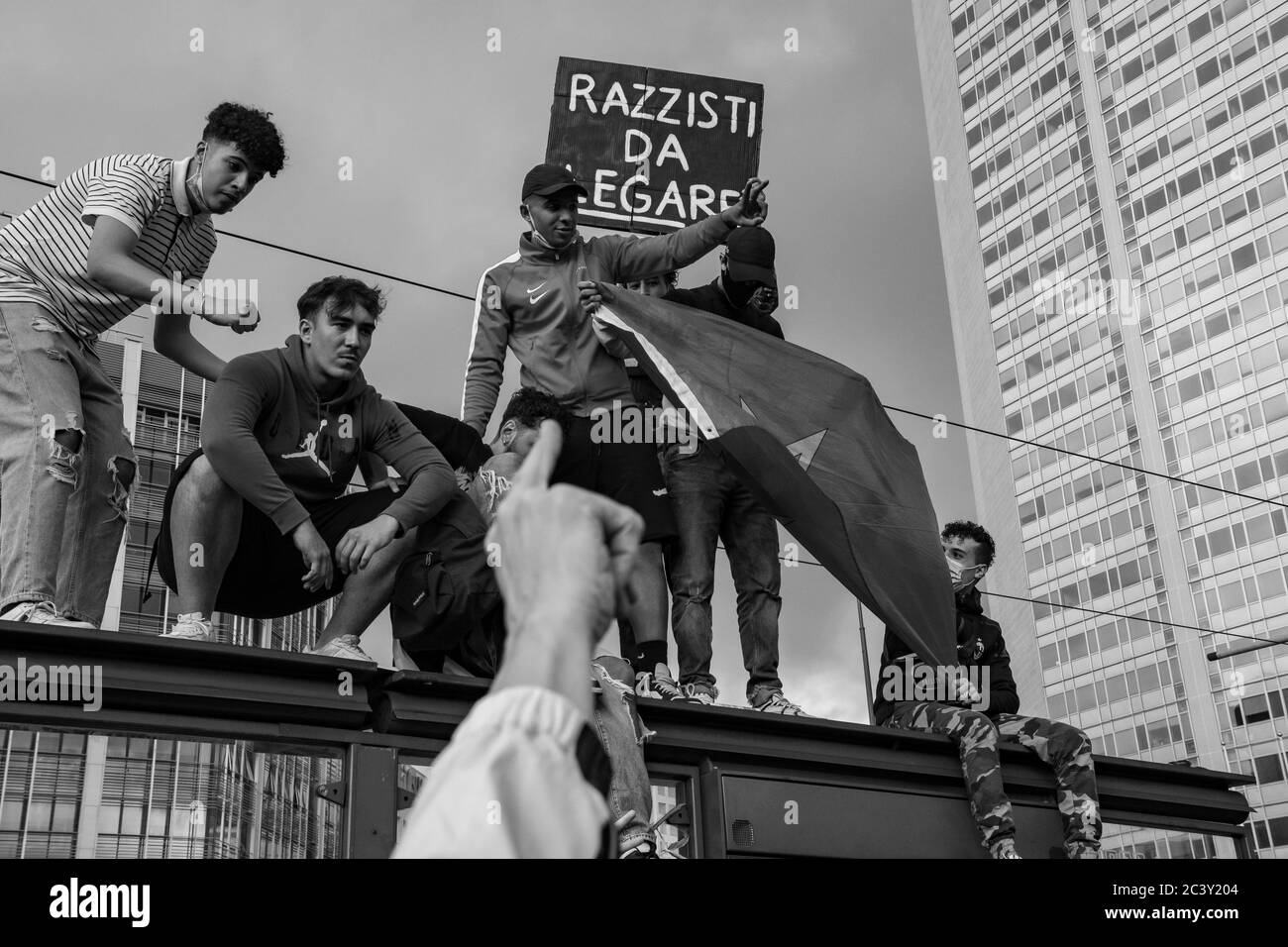 Un giovane protetore che tiene un consiglio 'Razzisti da Legare' durante l'assemblea di protesta in solidarietà al movimento BLM di fronte alla stazione centrale di Milano. Foto Stock