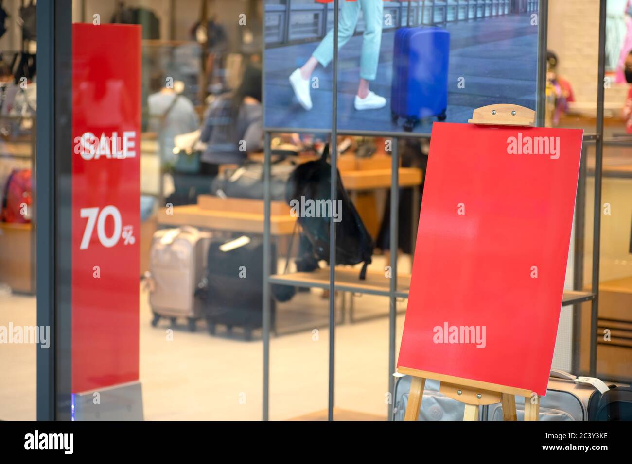 Cartello bianco mockup con in piedi presso il negozio di borse e bagagli, Mock up schermo rosso vuoto cornice annunci per inserire informazioni Foto Stock