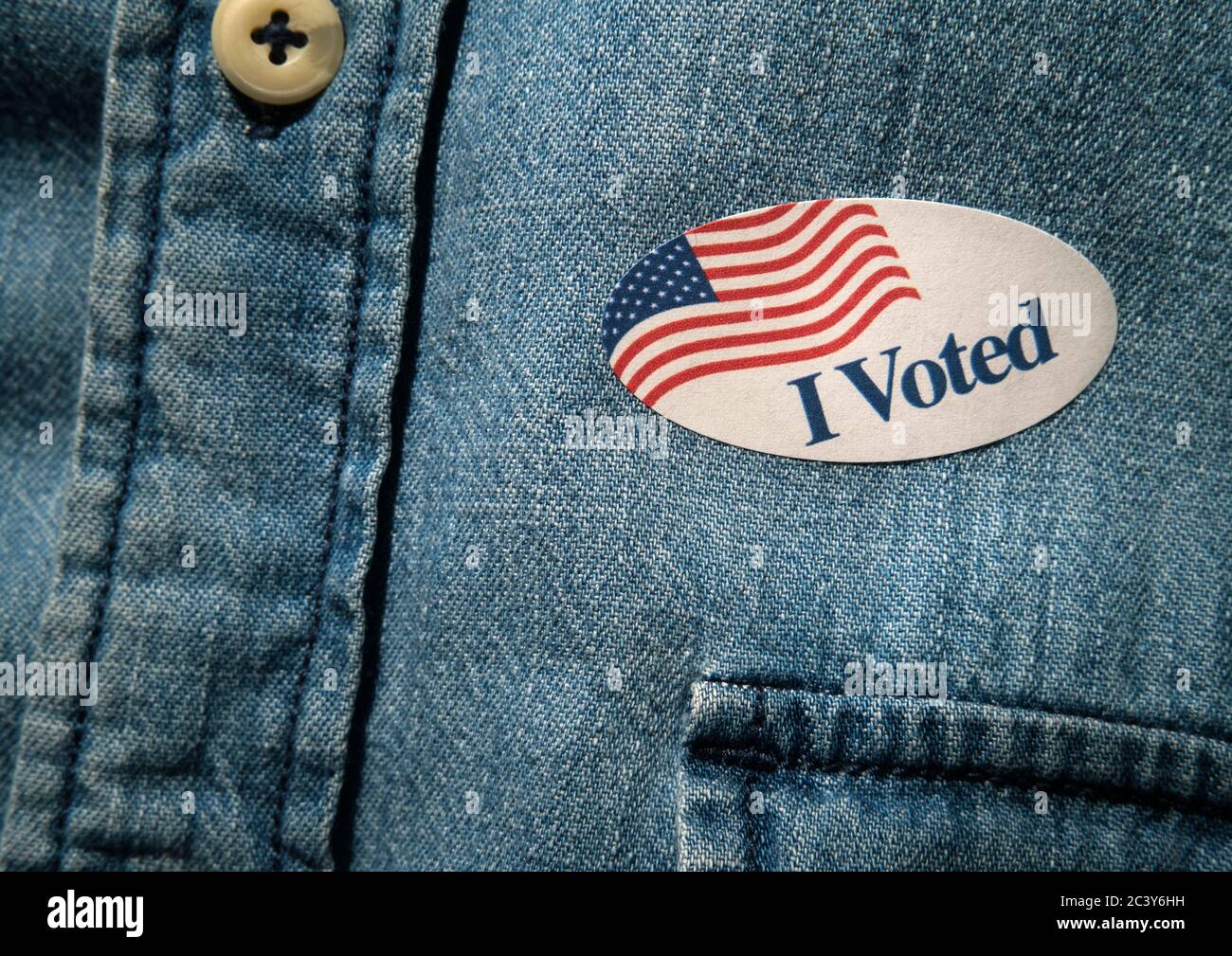 Primo piano di ho votato l'adesivo sulla camicia in denim Foto Stock