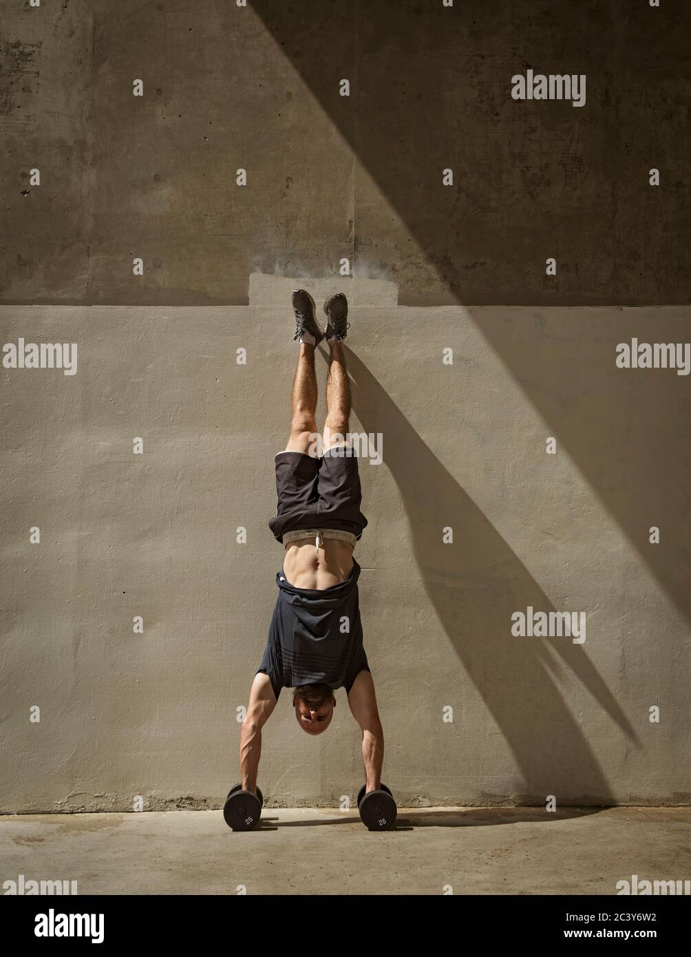 Uomo che fa la mano accanto al muro Foto Stock