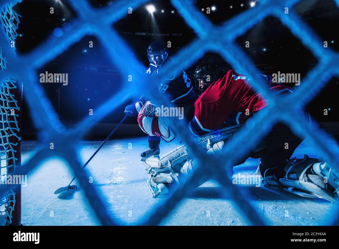 Goalie di Hockey che difende la rete contro il forward Foto Stock