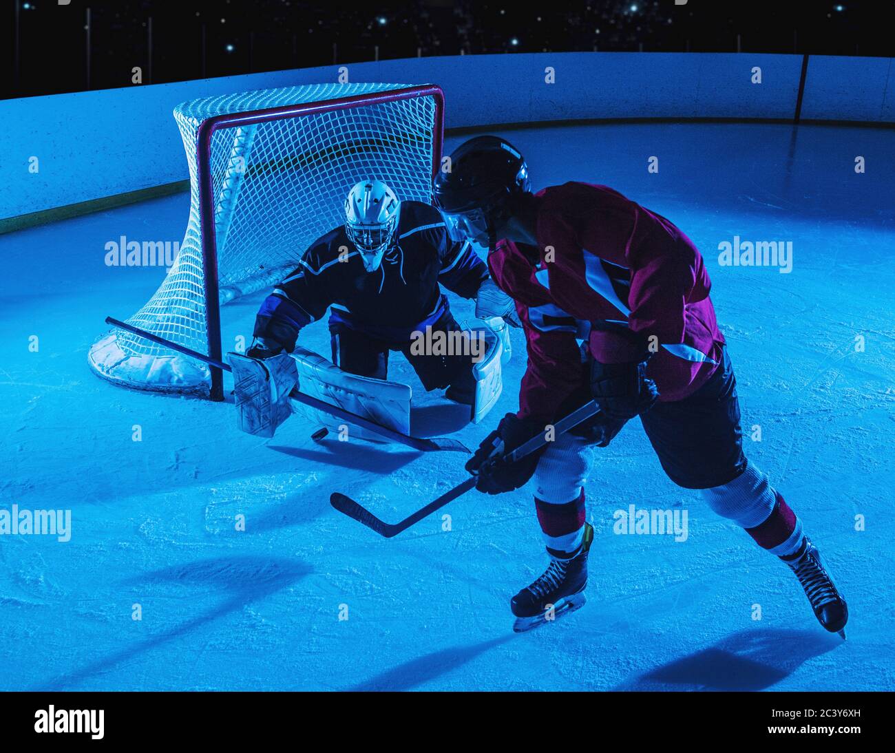Goalie di Hockey che difende la rete contro il forward Foto Stock