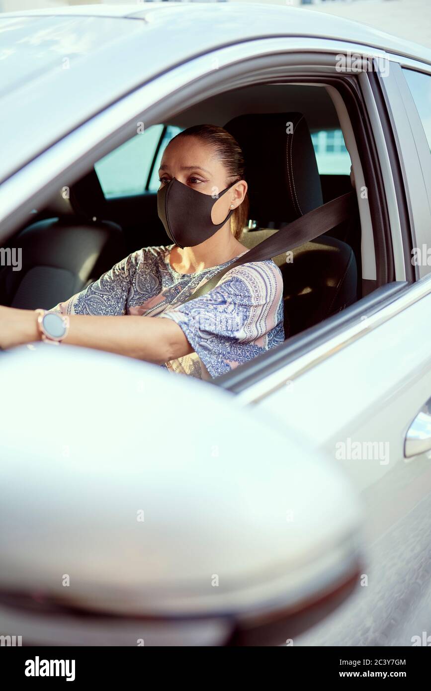 Donna con maschera di guida auto Foto Stock