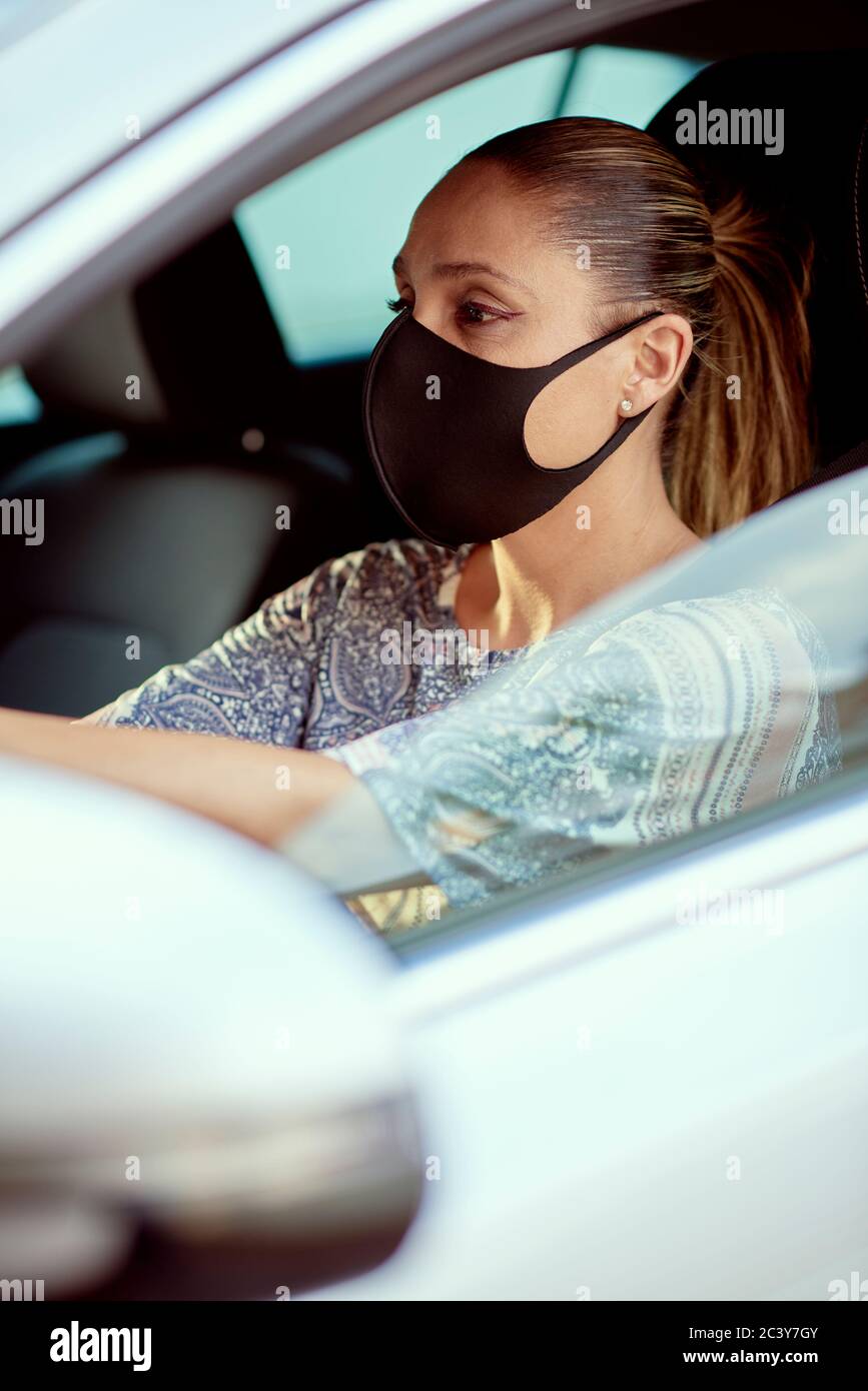 Donna con maschera di guida auto Foto Stock