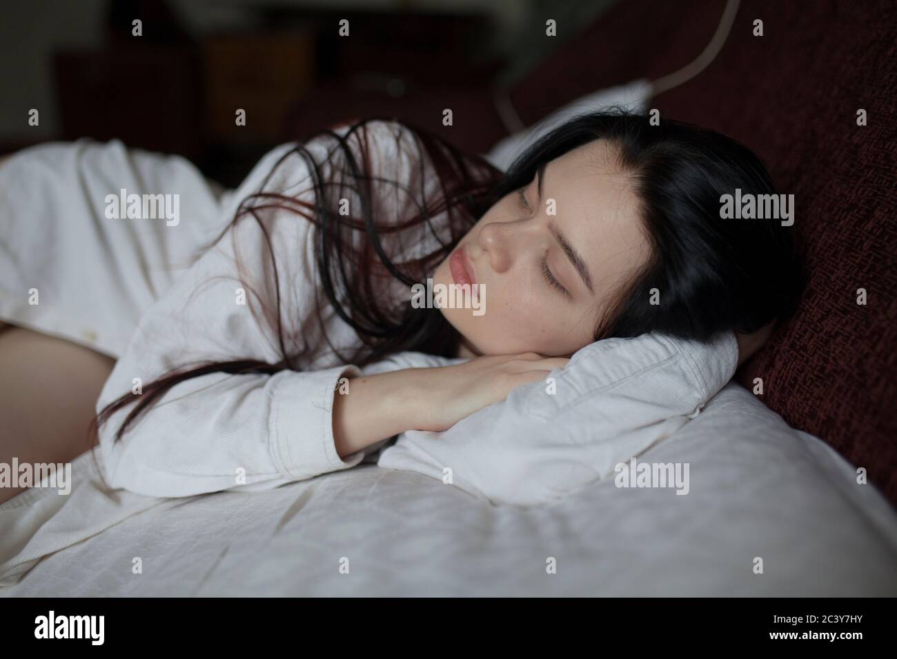 Giovane donna giaceva sul letto Foto Stock