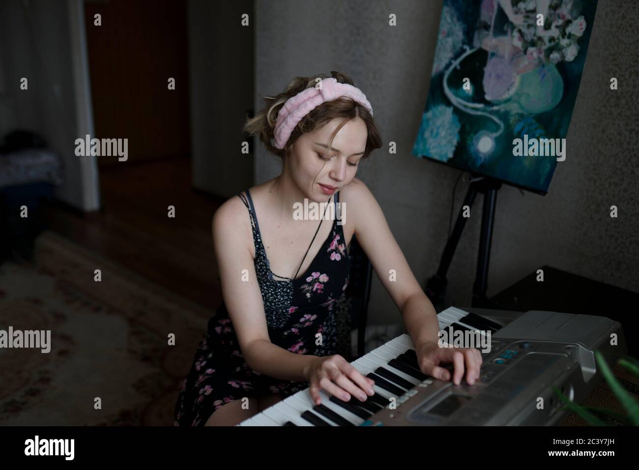 Donna che gioca la tastiera a casa Foto Stock