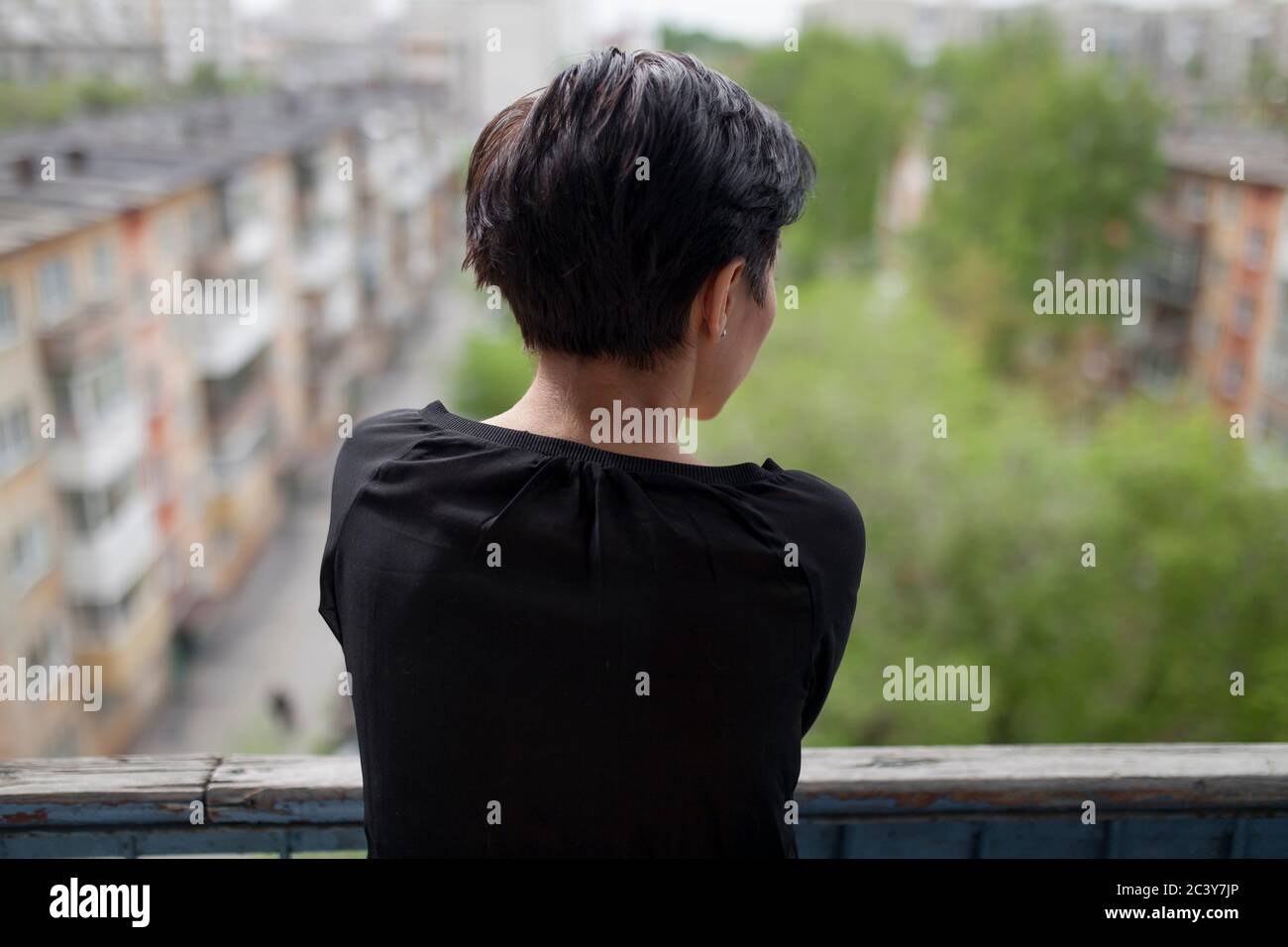 Vista posteriore della donna sul balcone Foto Stock