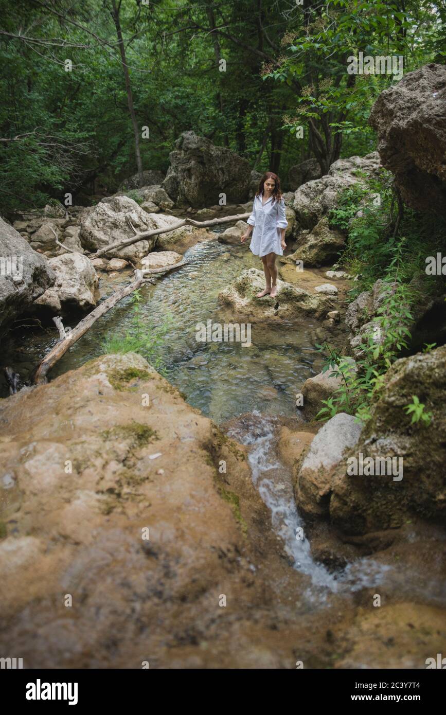 Ucraina, Crimea, giovane donna in piedi sulla roccia nel fiume Foto Stock