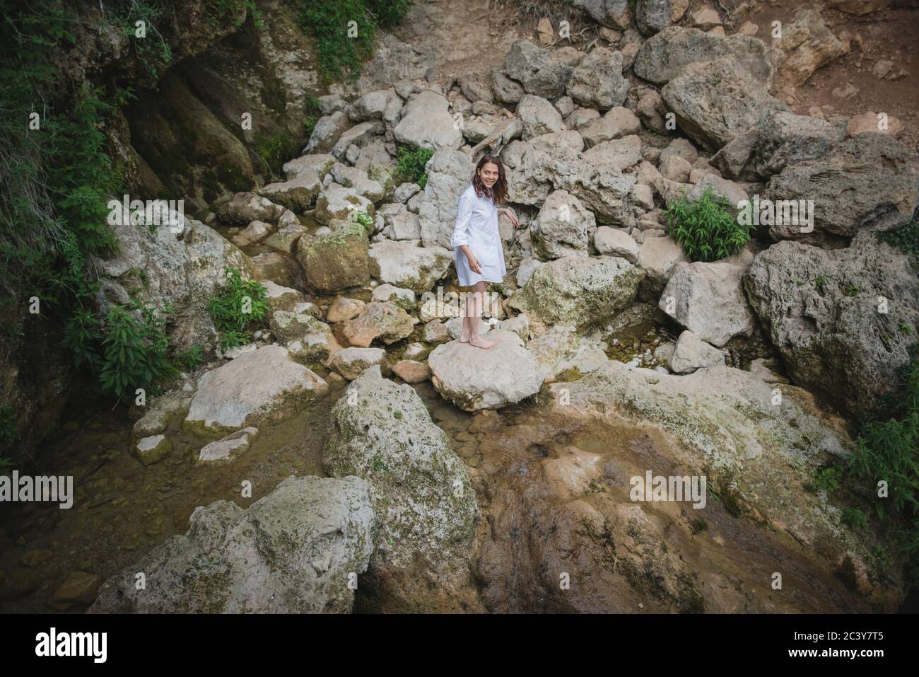 Ucraina, Crimea, giovane donna in piedi sulla roccia nel fiume Foto Stock