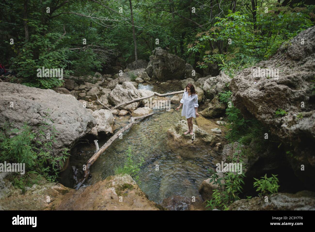 Ucraina, Crimea, giovane donna in piedi sulla roccia nel fiume Foto Stock