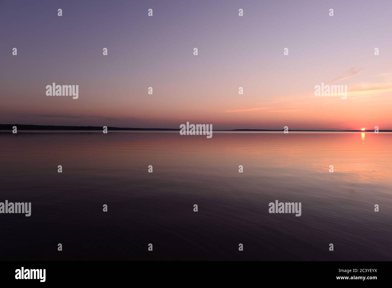 Tramonto tranquillo sul lago sotto il cielo senza nuvole Foto Stock