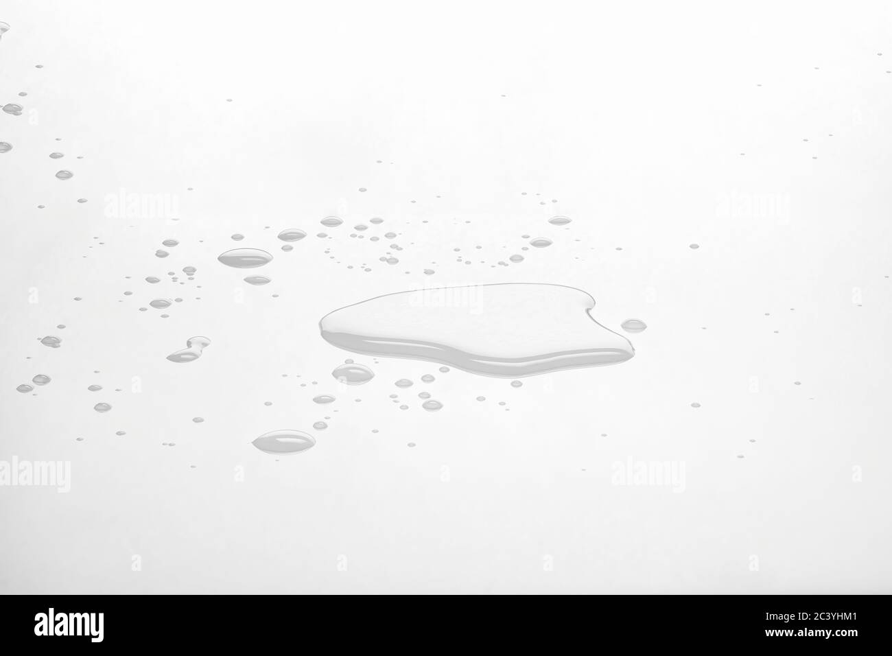 Pozzanghere e gocce d'acqua sulla superficie riflettente bianca. Vista frontale e messa a fuoco profonda. Foto Stock