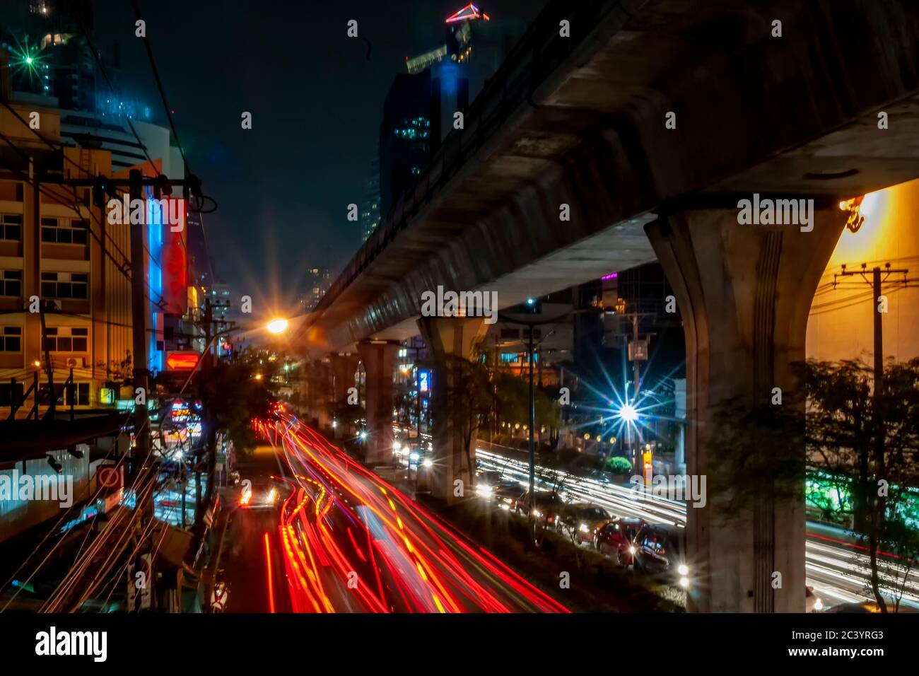Bella immagine notturna del traffico su Sukhumvit Road con lunghi sentieri colorati di luci mobili auto, Bangkok, Thailandia Foto Stock