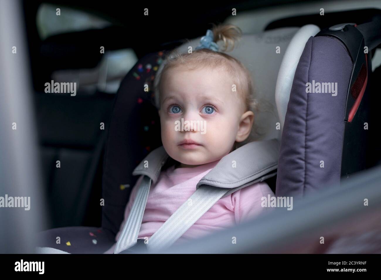 Bambina in un seggiolino per bambini in suv Foto Stock