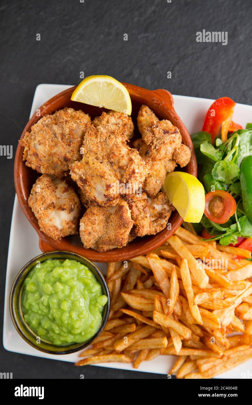 Guance a raggi, note anche come pomelli di skate, dai raggi di spina, Raja clavata, che sono state rivestite in pangrattato e cotto in forno. Servita con il c fatto in casa Foto Stock