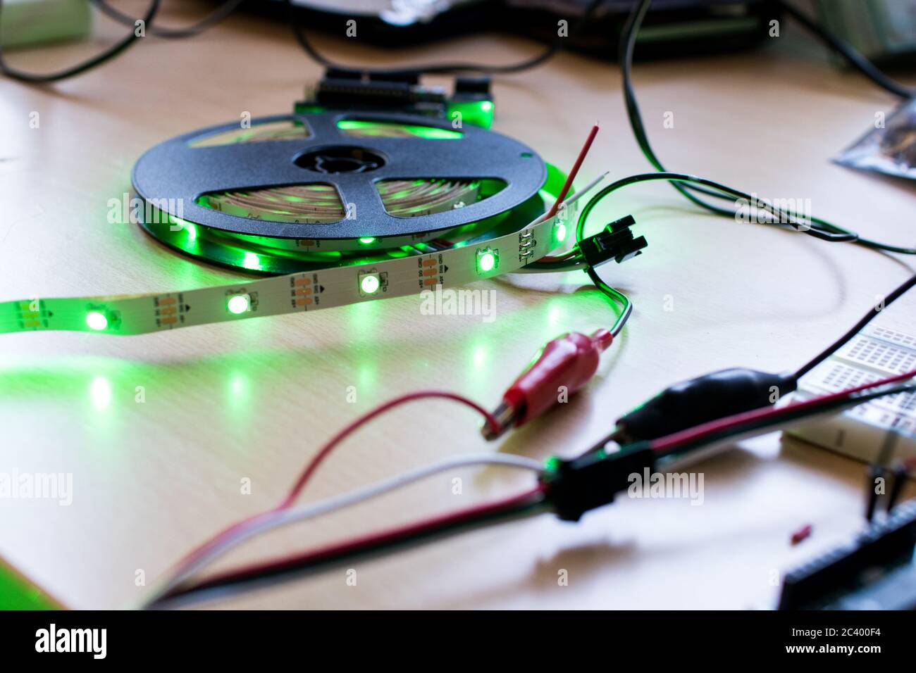 Banda LED RGB indirizzabile controllata da un microcontrollore open source per avere un flusso di colore verde. Progetto maker per l'illuminazione ambientale fai da te. Spie per Foto Stock