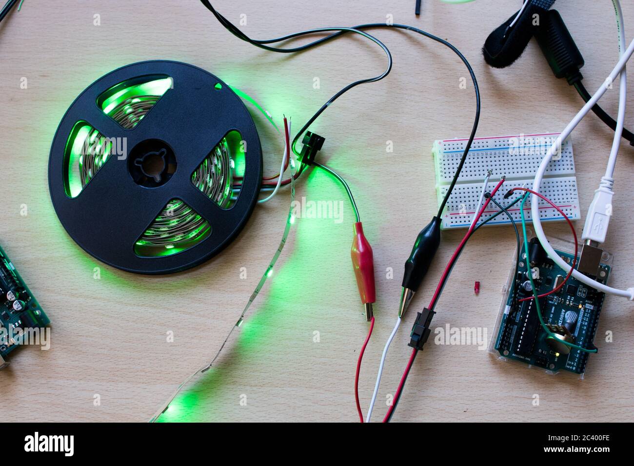 Banda LED RGB indirizzabile controllata da un microcontrollore open source per avere un flusso di colore verde. Progetto maker per l'illuminazione ambientale fai da te. Spie per Foto Stock