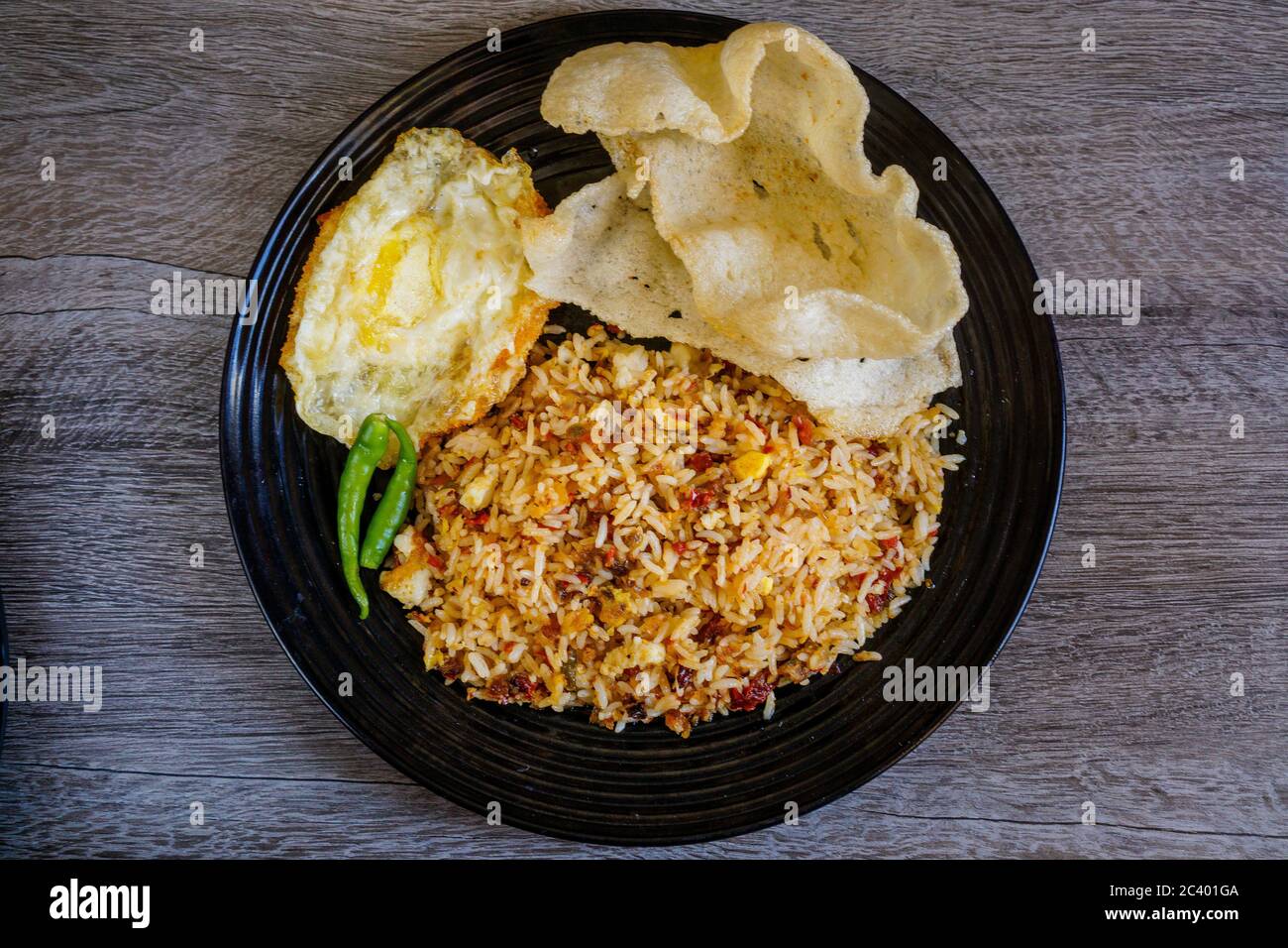 Riso fritto speziato con peperoncino essiccato con uova fritte e cracker di pesce. Foto Stock