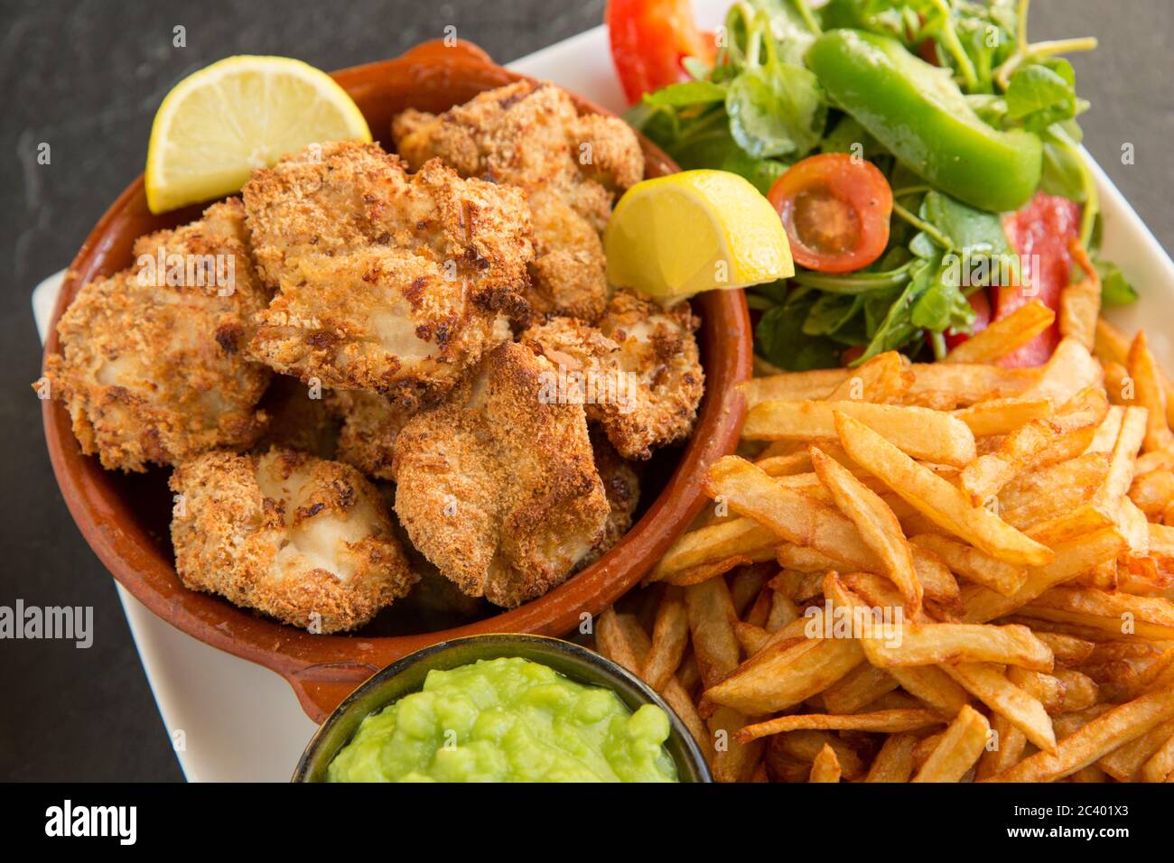 Guance a raggi, note anche come pomelli di skate, dai raggi di spina, Raja clavata, che sono state rivestite in pangrattato e cotto in forno. Servita con il c fatto in casa Foto Stock