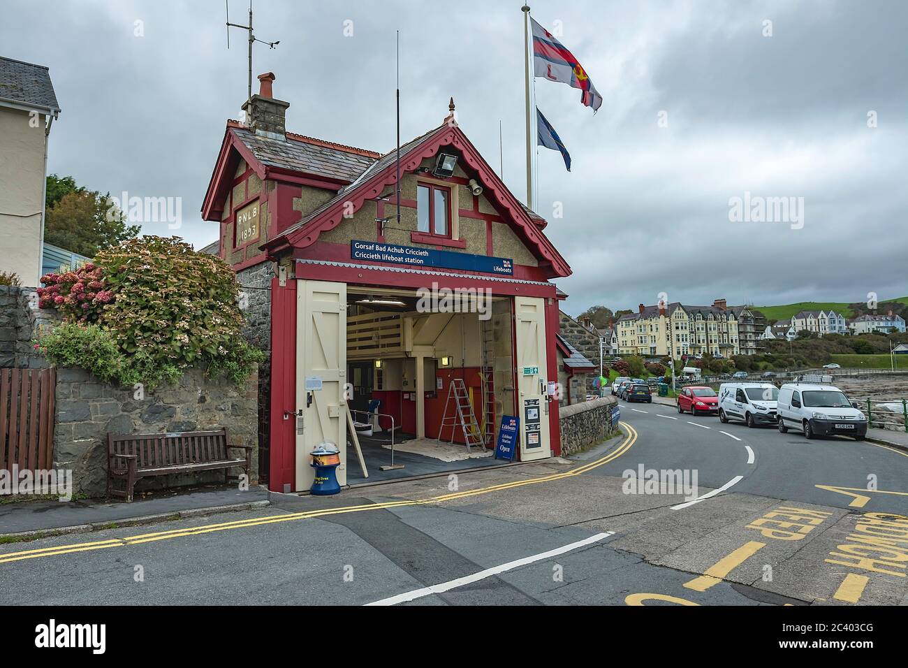 Stazione Lifeboat RNLI Criccieth, con porte aperte e battenti la bandiera RLNI. Foto Stock