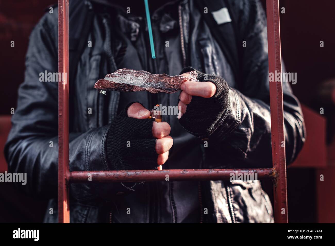 Tossicodipendente di fumare oppio sul foglio di stagno, aka inseguono il drago, close up delle mani con il fuoco selettivo Foto Stock