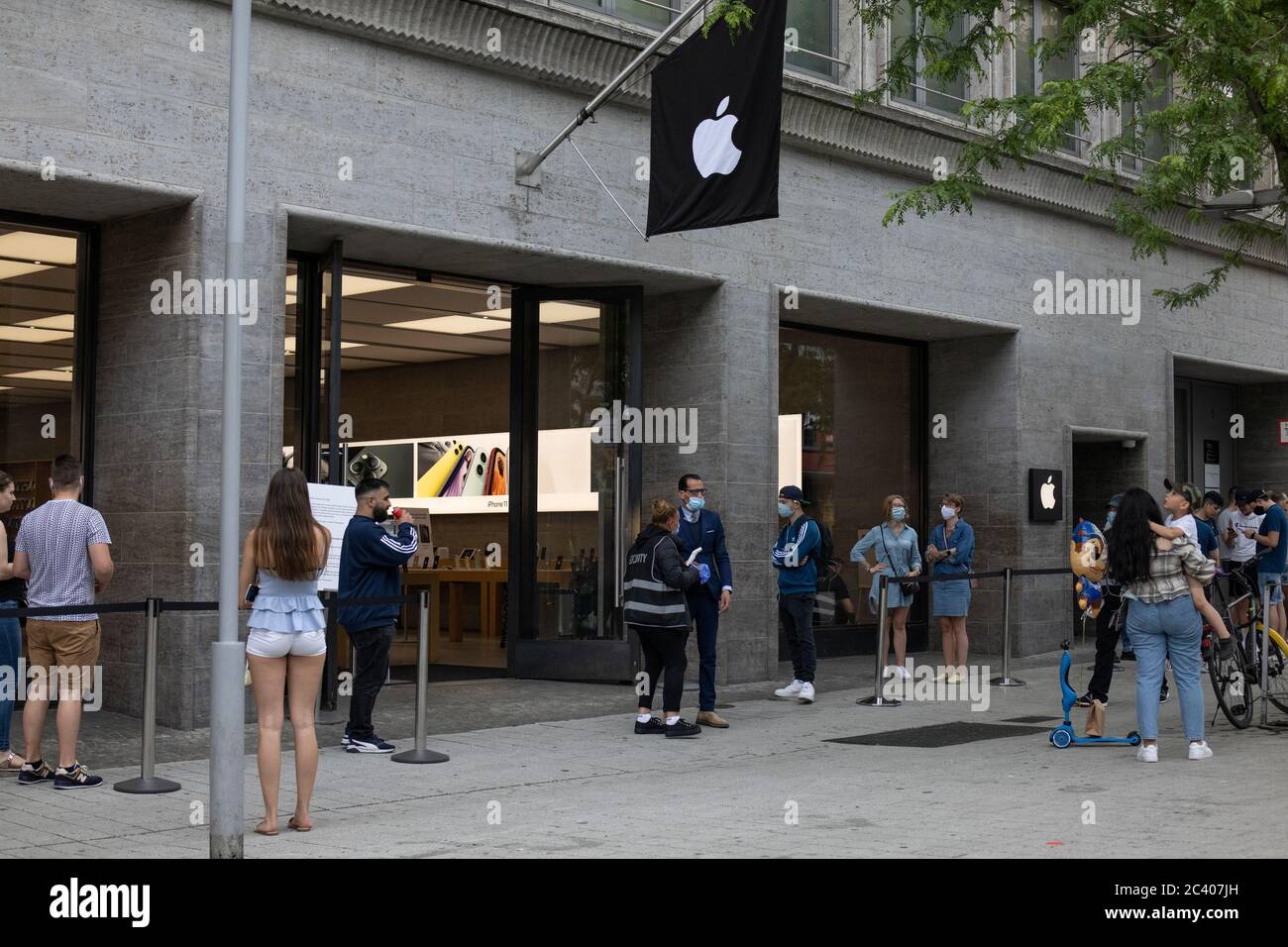 Gli acquirenti si accodano con maschere facciali in una linea di distanza sociale fuori da un negozio Apple nel centro di Hannover, Germania Foto Stock