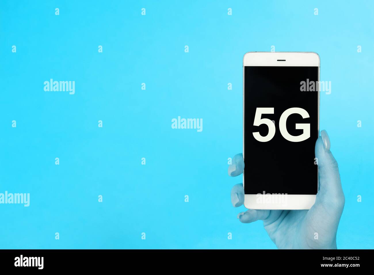 Sfondo creativo, tenendo a mano un telefono con un simbolo 5G. Il concetto di rete 5G, Internet mobile ad alta velocità, reti di nuova generazione Foto Stock