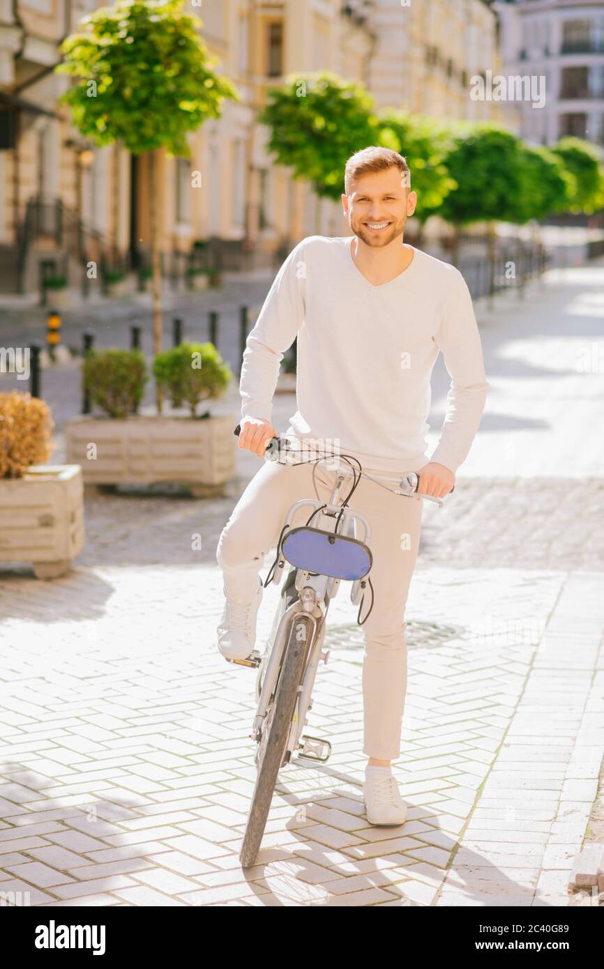 Attraente giovane uomo con la bearded in piedi con una bicicletta. Foto Stock