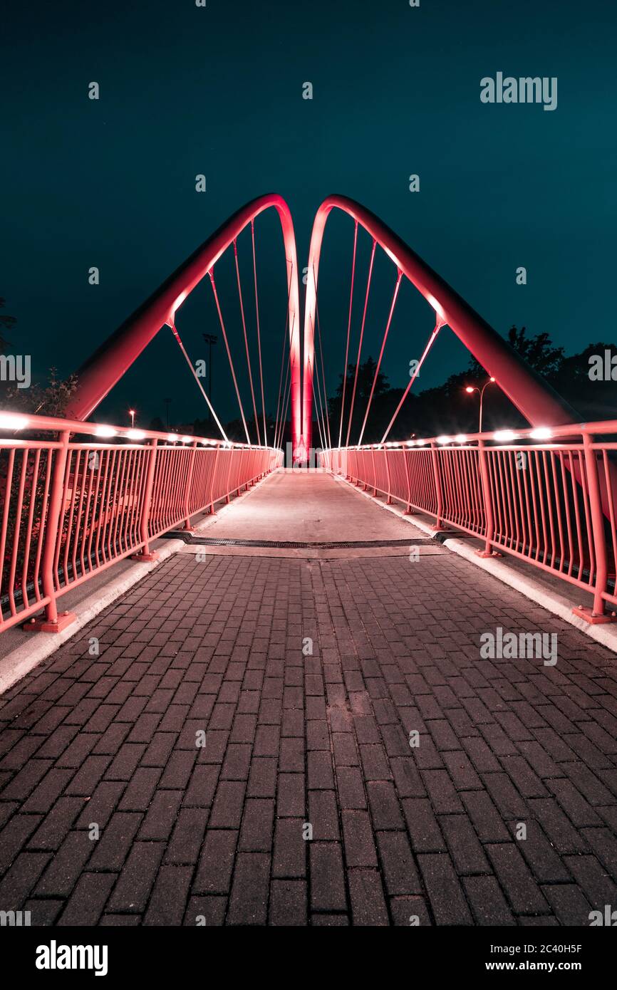 Bydgoszcz di notte. Il famoso ponte pedonale in bicicletta sulla rotta universitaria nelle luci notturne della città. Foto Stock