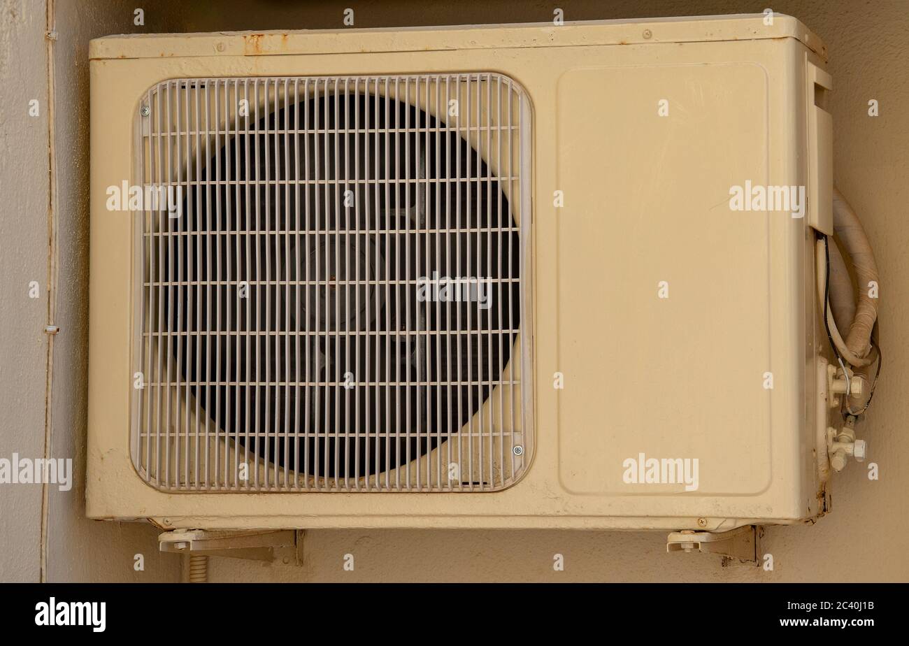 Compressore dell'unità di climatizzazione fuori casa. Ventola condensatore per supporto sistema di raffreddamento residenziale. apparecchiatura di condizionamento macchinari appesi su exte Foto Stock