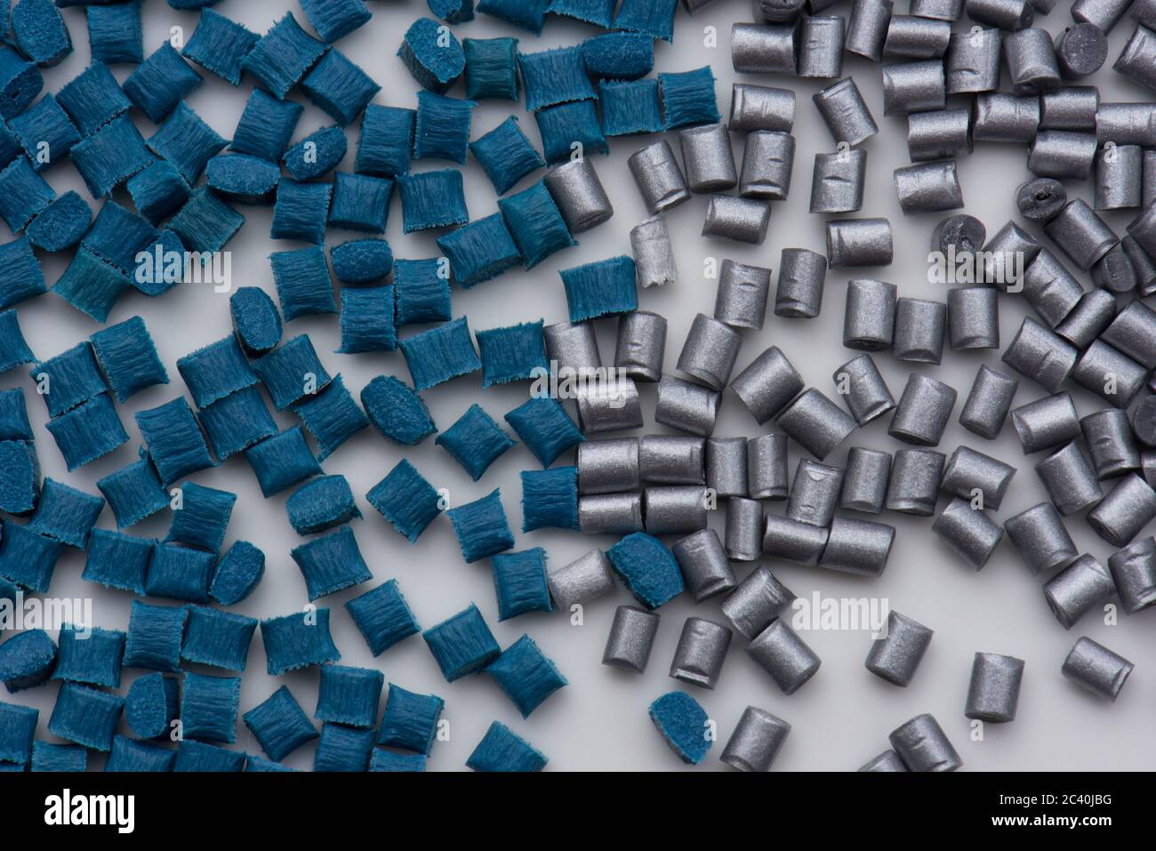 granulati di polimero plastico rinforzato con fibra di vetro blu e non rinforzato con argento su bianco Foto Stock