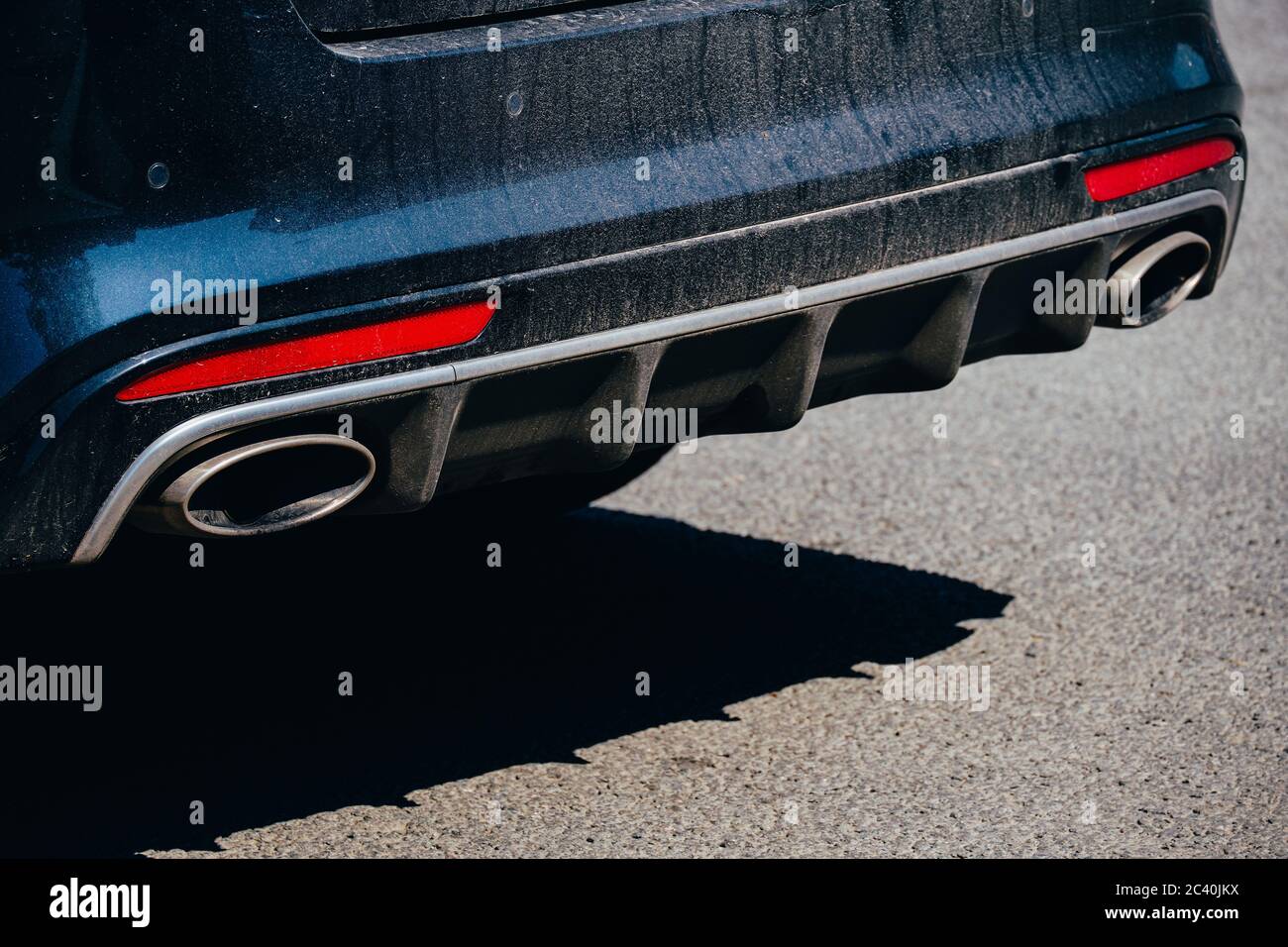 Primo piano del tubo di scarico dell'auto sulla strada. Foto Stock