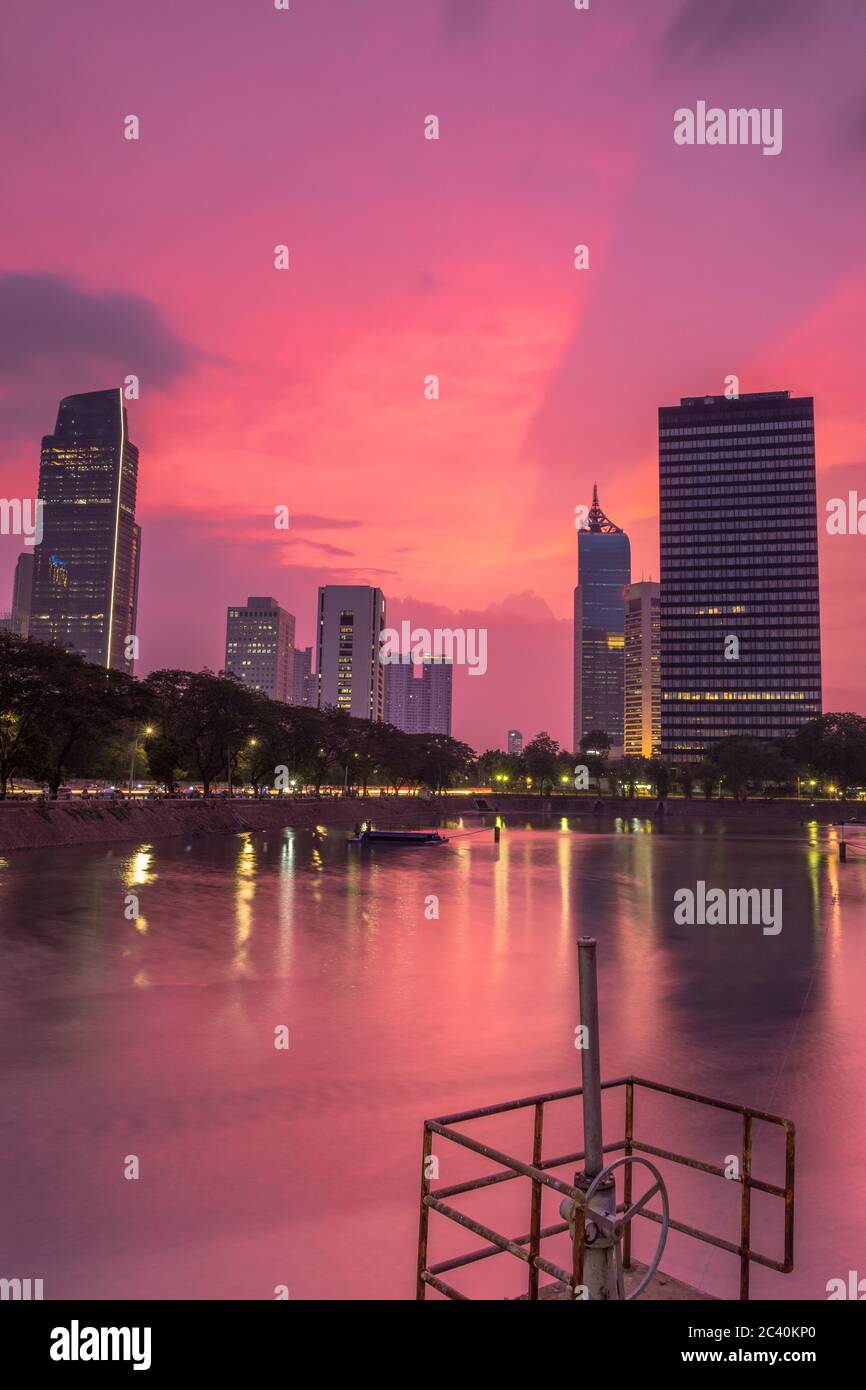 Splendido scenario di tramonto su un bacino idrico nel centro di Giacarta con uffici e centri d'affari sullo sfondo, Giacarta, Indonesia Foto Stock