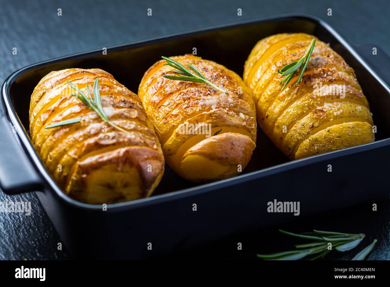 Patate Hasselback. Patate a filetto dalla Svezia con aglio ed erbe grigliate nel forno. Foto Stock