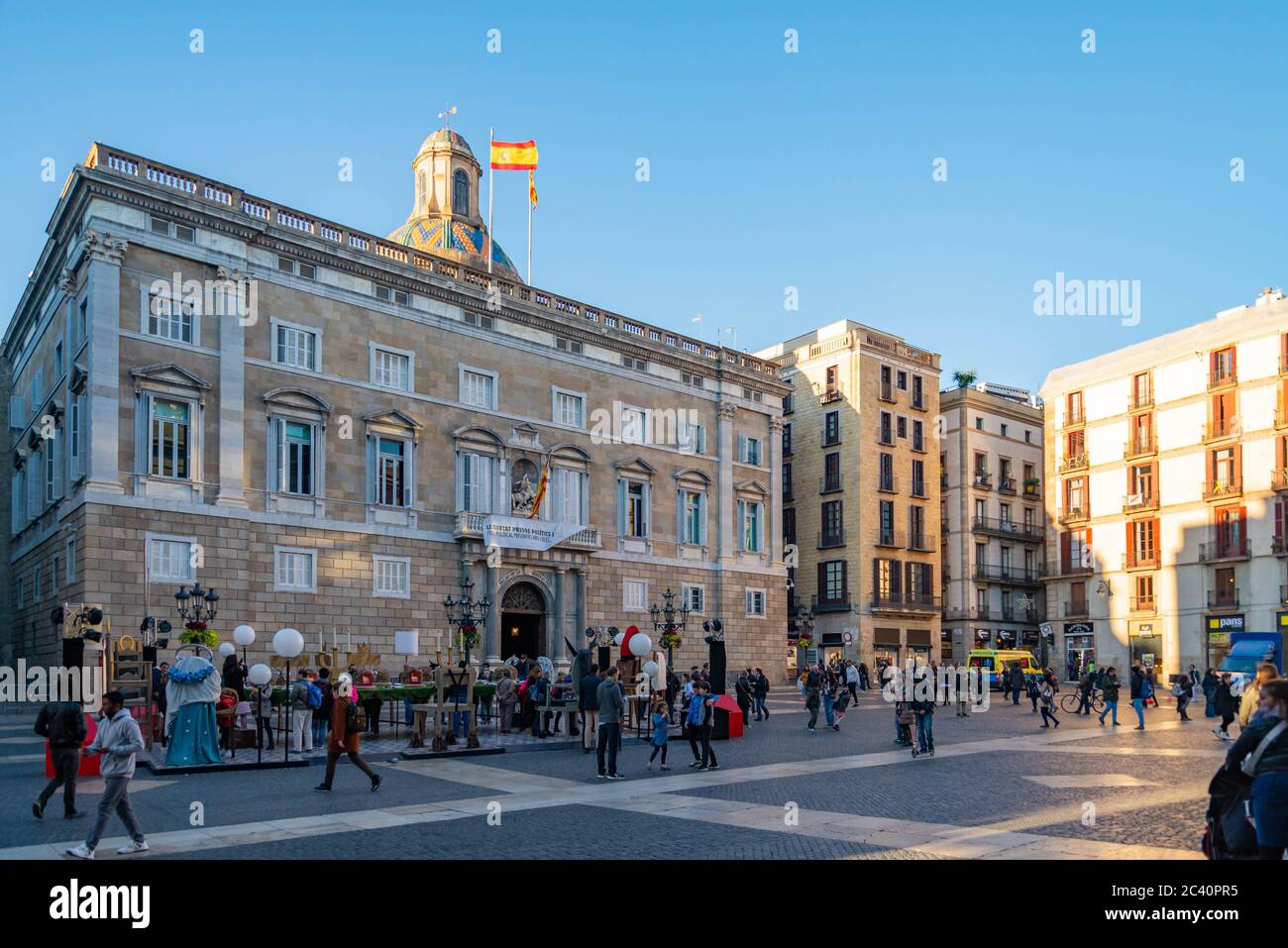 La gente a piedi nella parte anteriore del Palazzo Generalitat della Catalogna in Sant Jaume square. Il palazzo ospita gli uffici della Presidenza della Generalitat Foto Stock