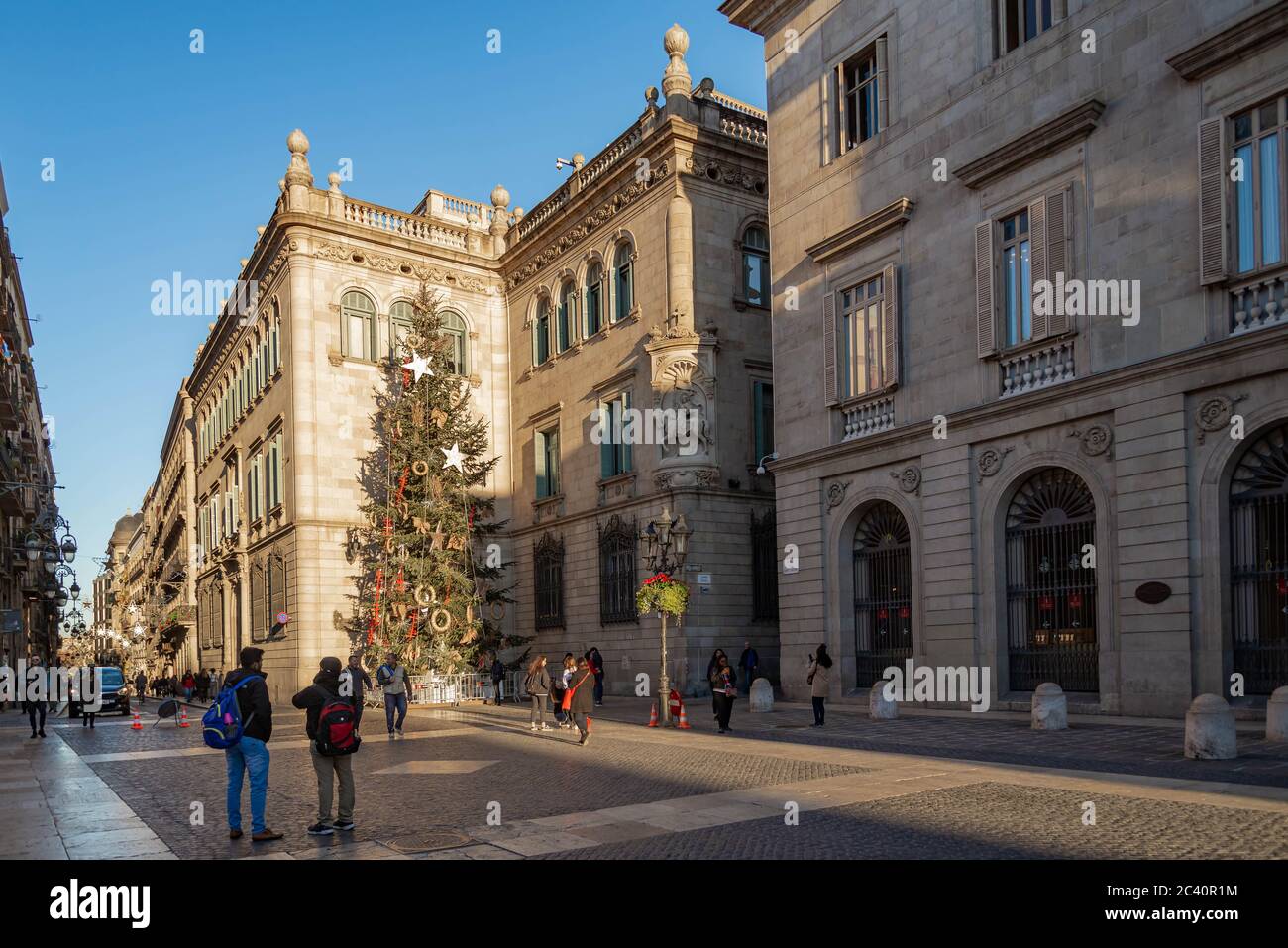 La gente a piedi nella parte anteriore del Palazzo Generalitat della Catalogna in Sant Jaume square. Il palazzo ospita gli uffici della Presidenza della Generalitat Foto Stock