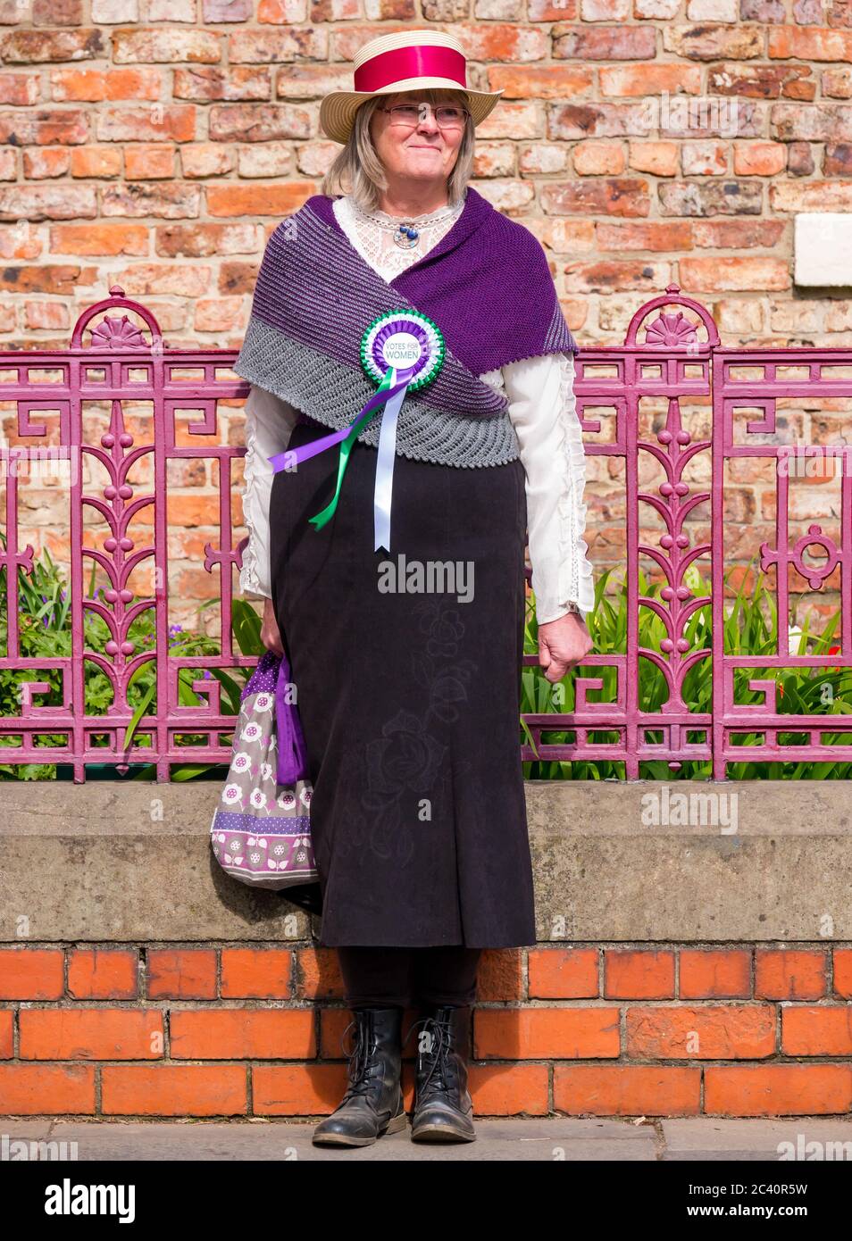 Donna vestita in costume d'epoca come suffragette con rosetta, Beamish Museum, Durham County, Inghilterra, UK Foto Stock