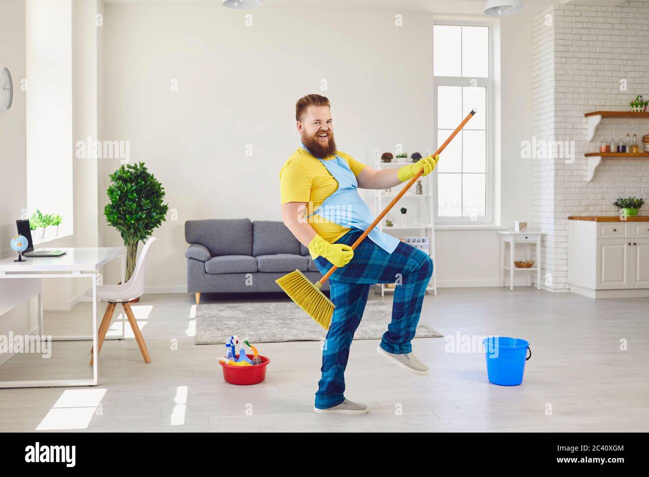 Casa pulita e divertente. Uomo positivo con scopa per pulizia. Foto Stock