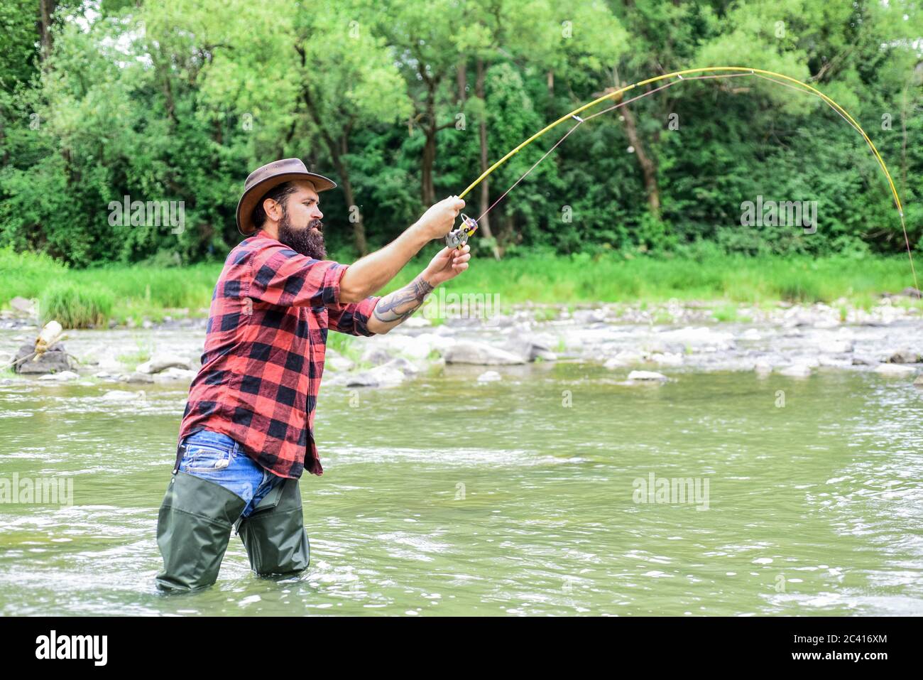 Tempo di smettere di vivere al lavoro. Hobby e attività sportive. Pothunter. Uomo maturo pesca a mosca. Uomo cattura pesce. pescatore bearded in acqua. Weekend estivo. Foto Stock