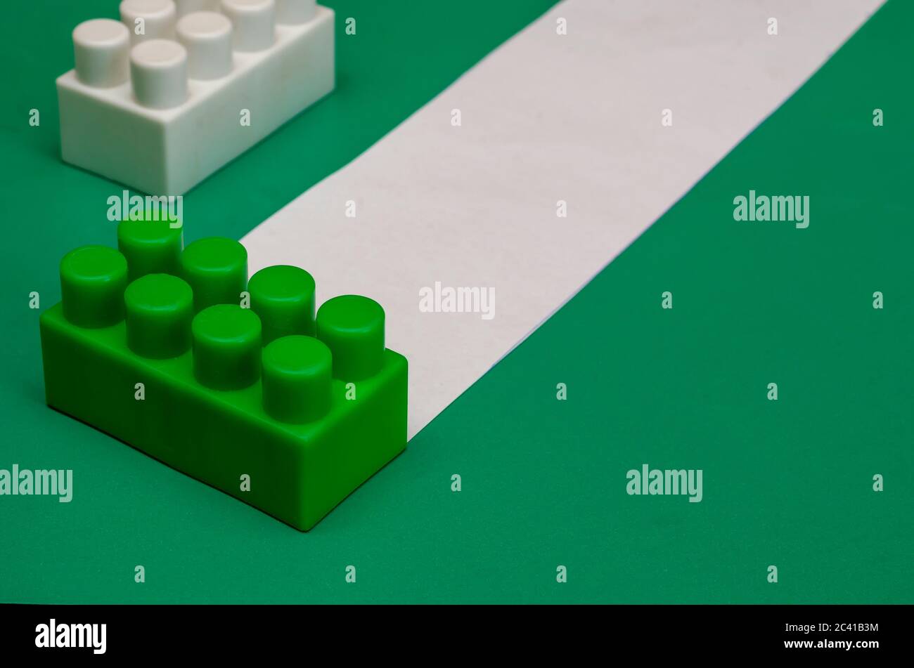 Sfondo bianco-verde con dettagli di un bambino designer. Sfondo creativo a due tonalità. Pensiero logico, business aziendale. Messa a fuoco selettiva. Copia s Foto Stock
