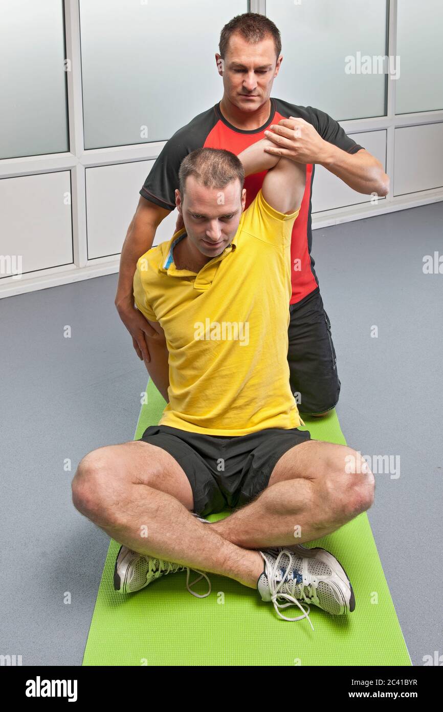 Personal trainer aiutando client in palestra Foto Stock
