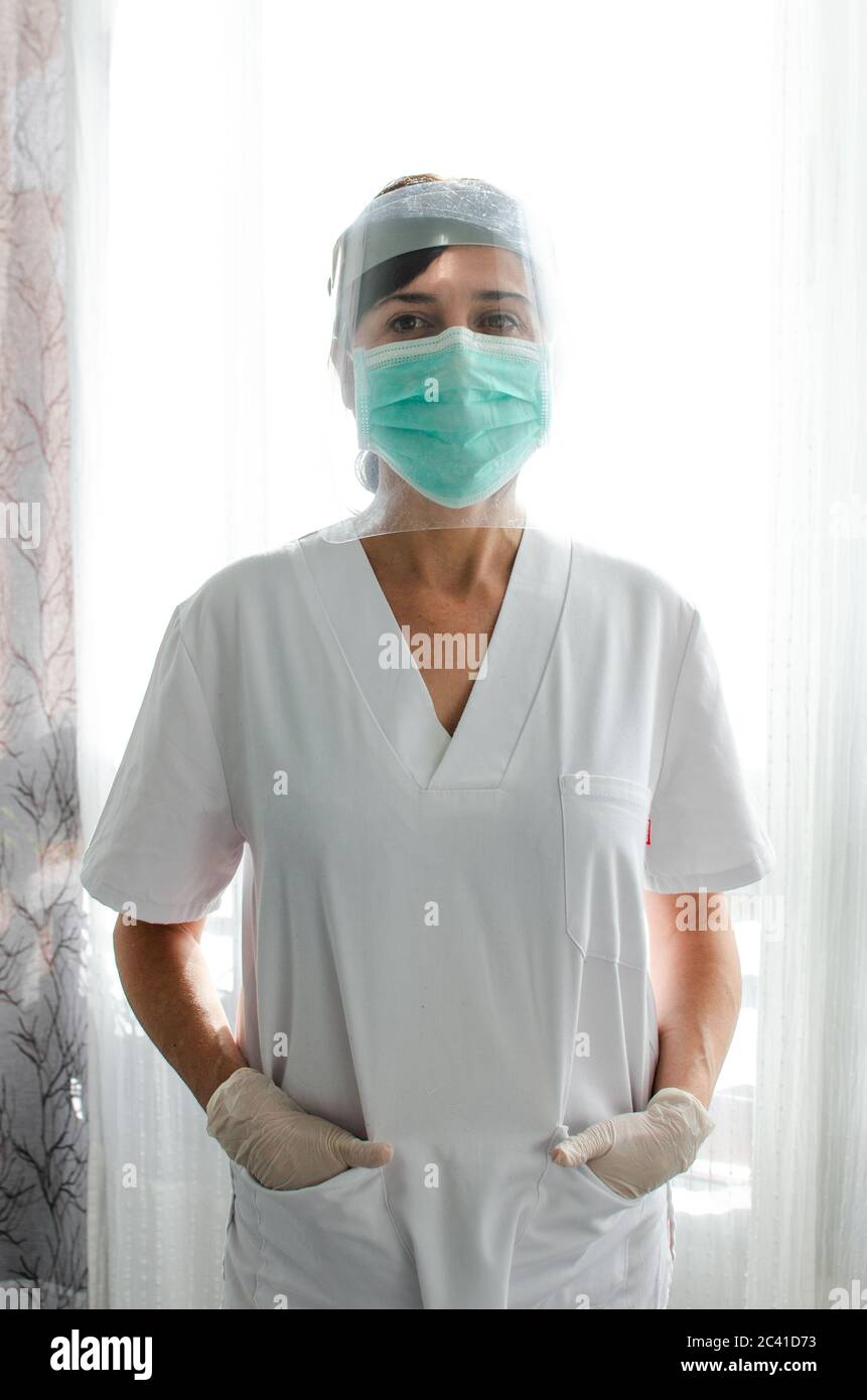 Infermiere in piedi con una visiera protettiva e una maschera chirurgica  Foto stock - Alamy
