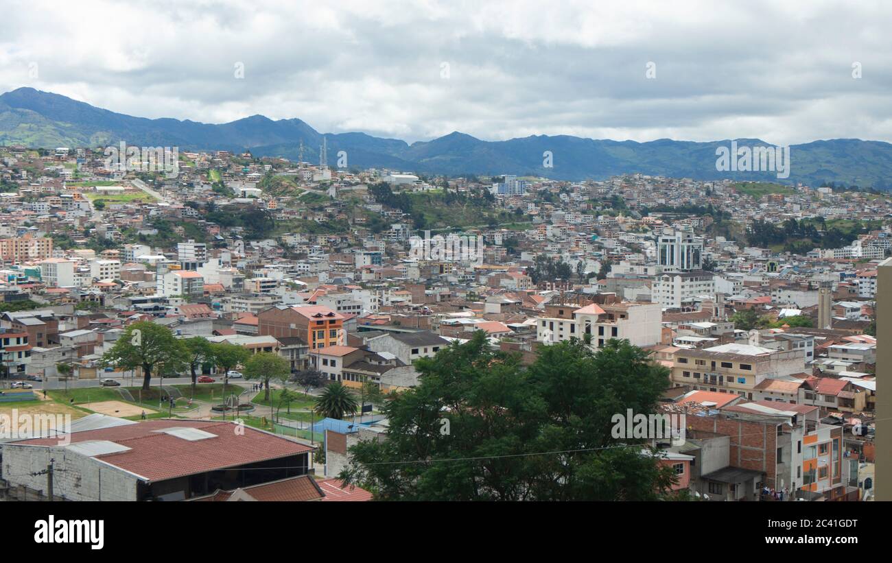 Vista panoramica della città di Loja in Ecuador con le montagne all'orizzonte in un pomeriggio nuvoloso Foto Stock