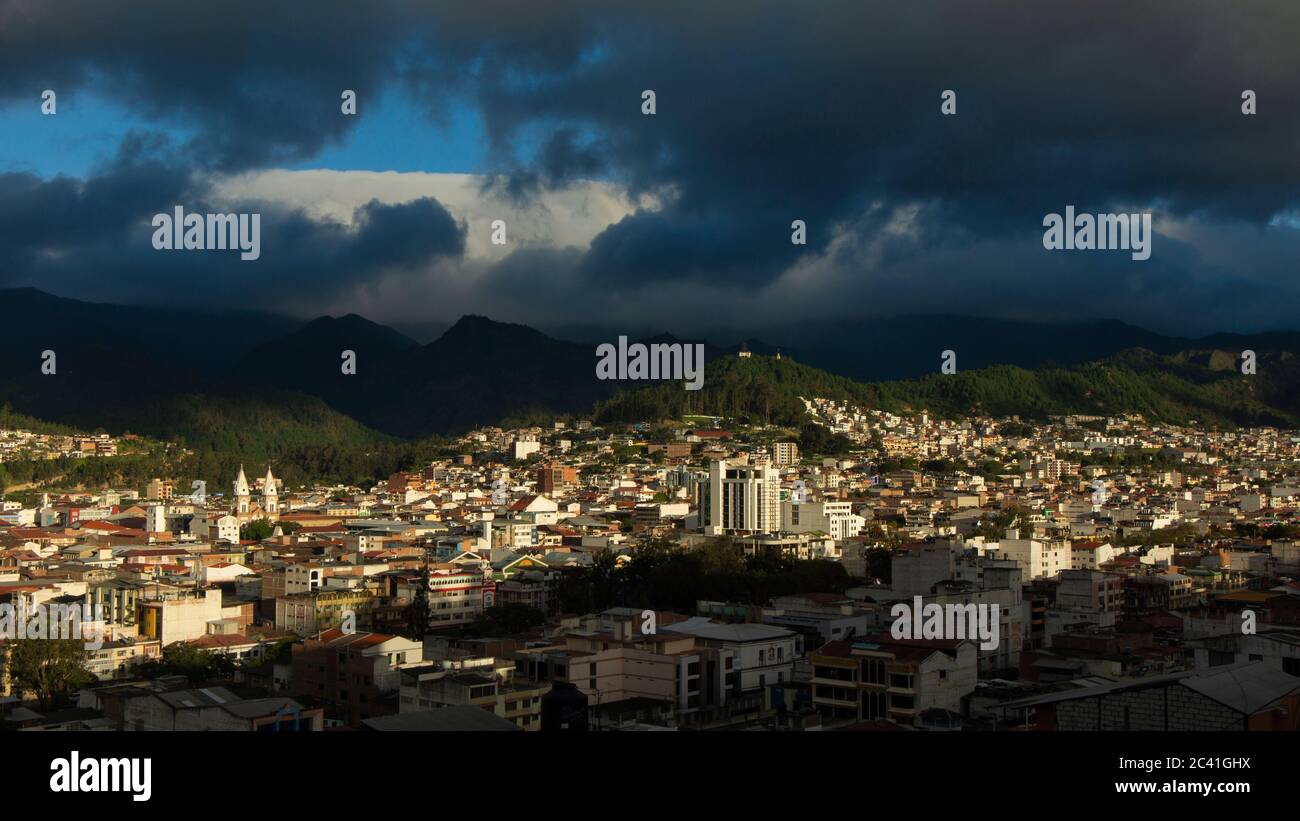 Vista panoramica della città di Loja in Ecuador con le montagne all'orizzonte in un pomeriggio nuvoloso prima della tempesta Foto Stock