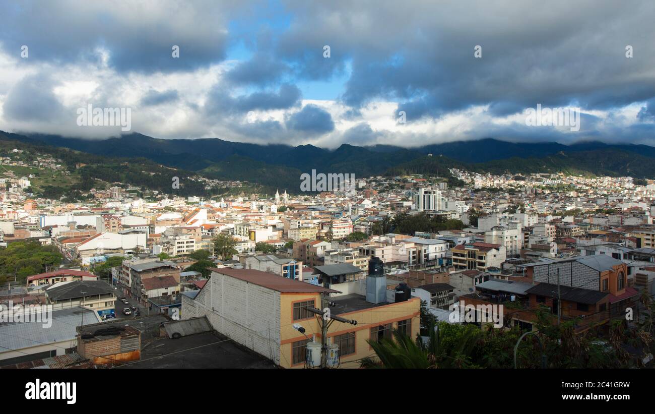 Vista panoramica della città di Loja in Ecuador con le montagne all'orizzonte in un pomeriggio nuvoloso prima della tempesta Foto Stock