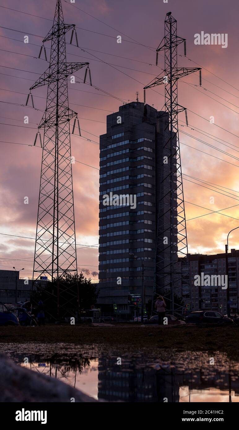 Linee elettriche e un edificio industriale con riflessi in acqua durante l'inverno. Foto di alta qualità Foto Stock