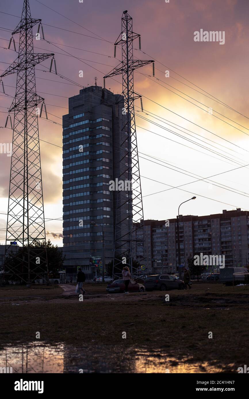 Linee elettriche e un edificio industriale con riflessi in acqua durante l'inverno. Foto di alta qualità Foto Stock