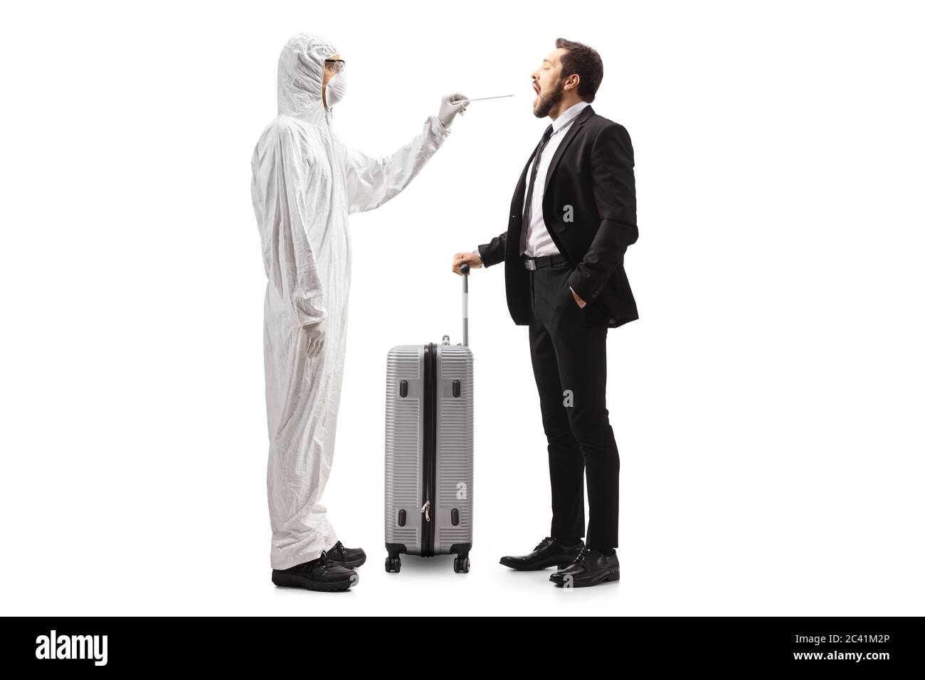 Profilo a lunghezza intera di un uomo in una tuta di nocciolo facendo un test di cotone gola a un uomo con una valigia isolata su sfondo bianco Foto Stock