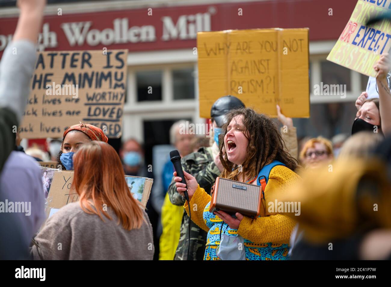 Richmond, North Yorkshire, UK - 14 giugno 2020: Una protesta femminile gridando ad una protesta della materia Black Lives. Circondato da altri manifestanti che indossano PP Foto Stock