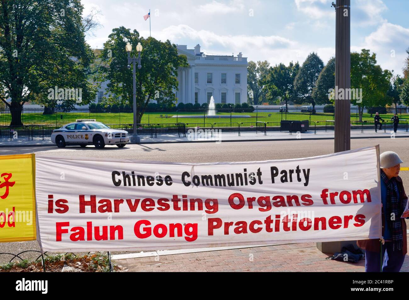 Attivista che ha un banner di fronte alla Casa Bianca, Washington, D.C., sulla raccolta di organi da parte di professionisti di Falun Gong in Cina Foto Stock
